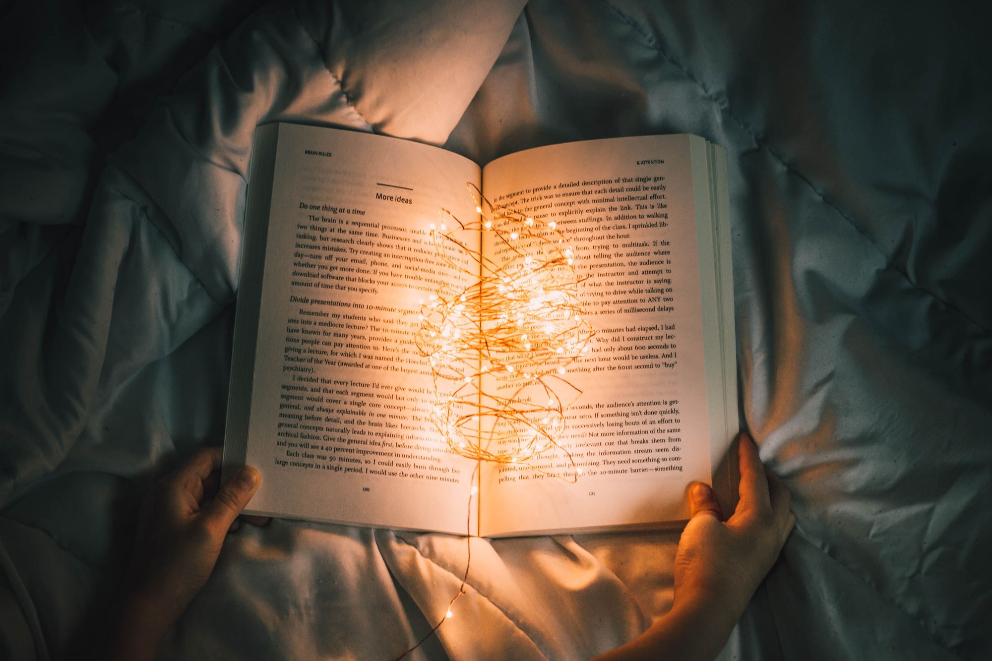 A story book being illuminated by fairy lights.