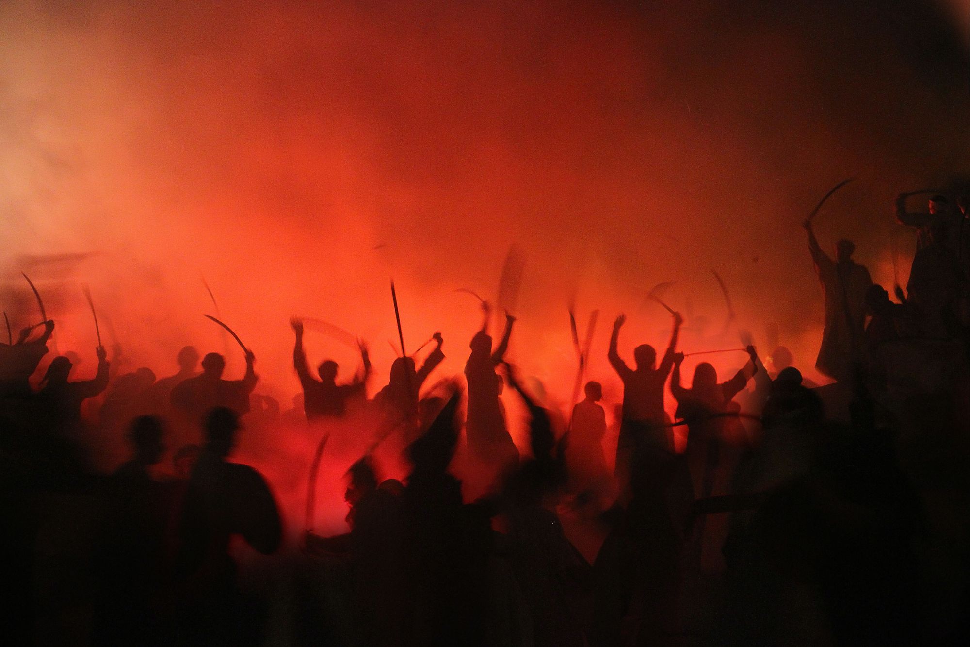 A crowd of warrior silhouettes going to battle in orange fog.