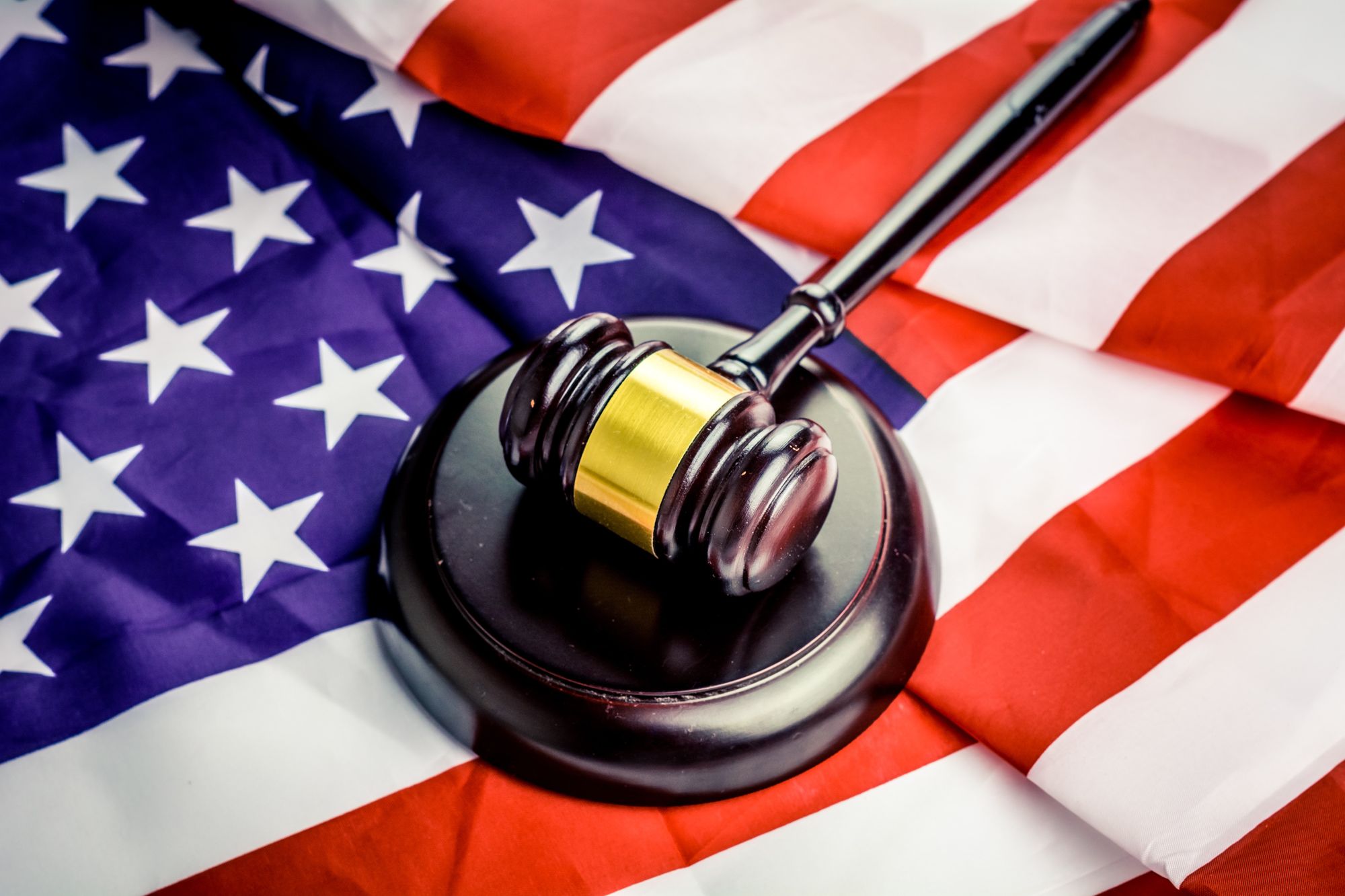 Judge's gavel resting on an American flag background.