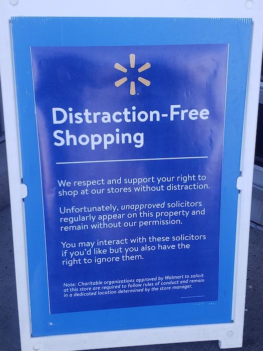 A blue Walmart sign about unapproved solicitors.