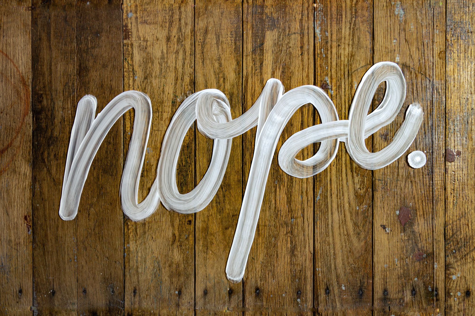The word "nope" painted in white on wooden boards.