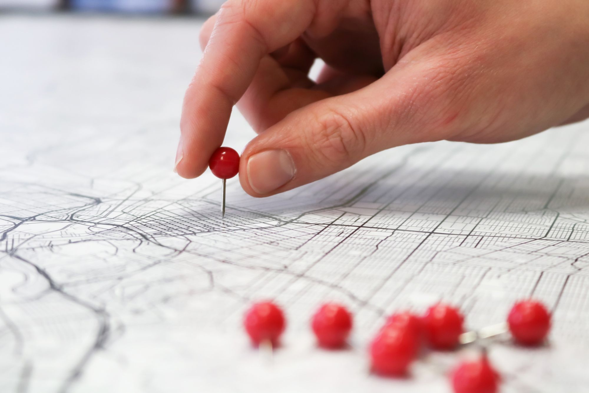 Hand with pin on map.