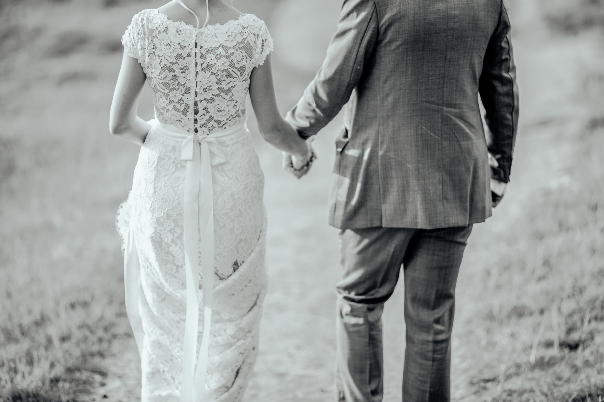 Married couple walk along a road.