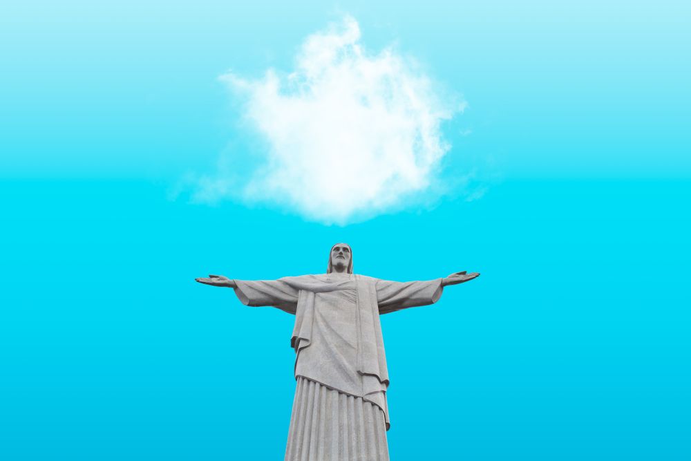 Statue of Jesus with arms open against a blue sky in Rio De Janeiro, Brazil.